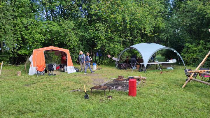 Spejderlejr med køkkentelt, partytelt, bålplads med vandslukker og grillriste